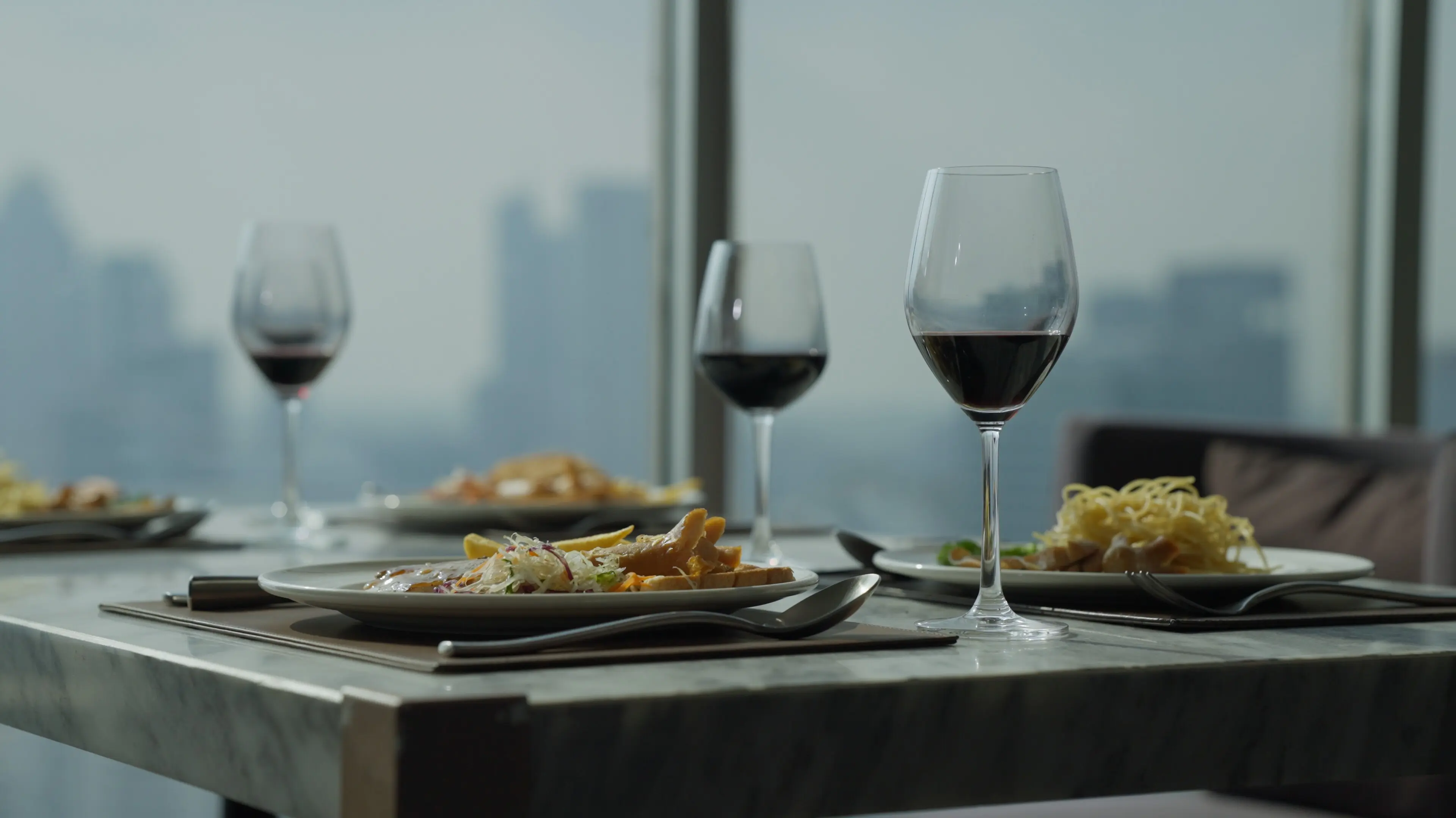 Luxury cuisine with a city skyline view; a luxurious dinner in a high-rise building.