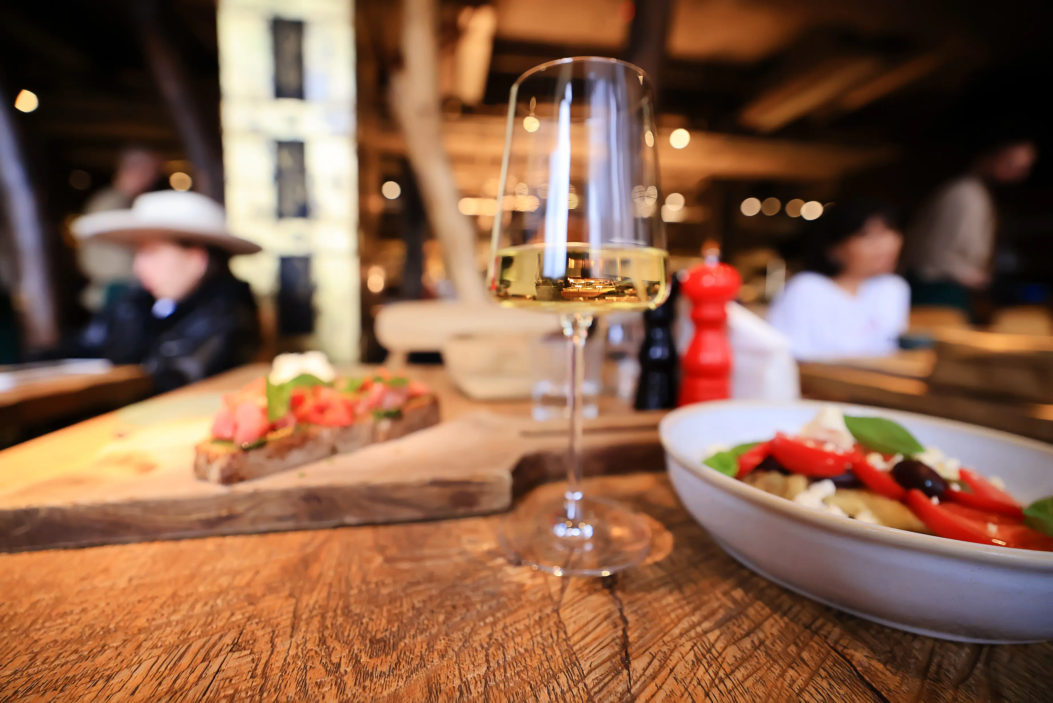 A glass of wine served on a restaurant table.